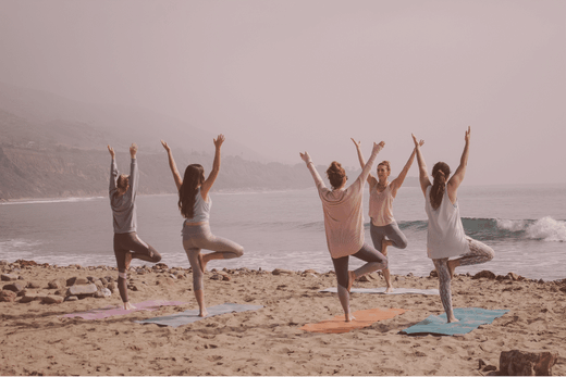 Groupe en yoga sur plage, QVCT pour santé mentale et performance entreprise.